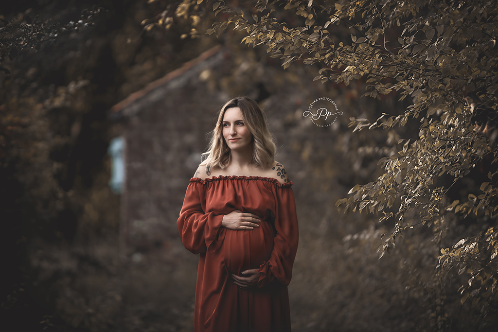 femme enceinte portant une belle robe fluide couleur terracotta dans le jardin d'un château
